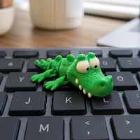 Croko le Crocodile Decontracte - figurine miniature 5cm sur un clavier d'ordinateur